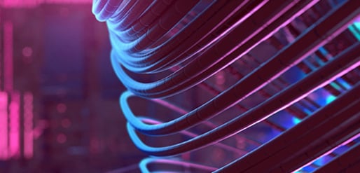 Kabel oder Lichtschläuche in leuchtenden Neonfarben von Blau über Türkis bis Pink. Der Hintergrund ist unscharf und ebenfalls in diesen Farben gehalten, was eine futuristische oder technologische Atmosphäre erzeugt.